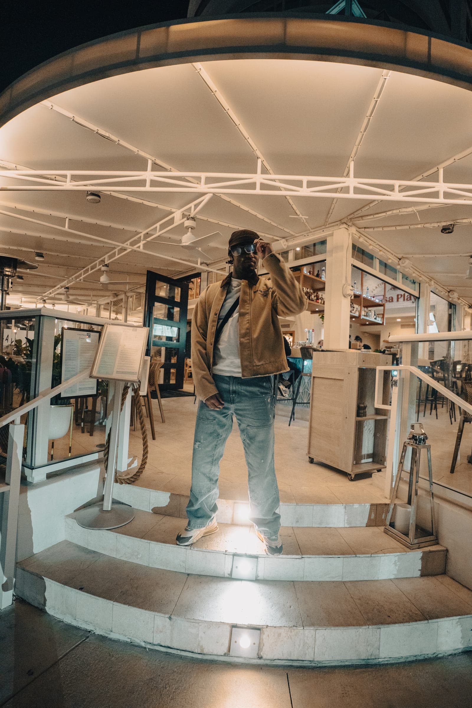 Man in a tan jacket standing in a bright store