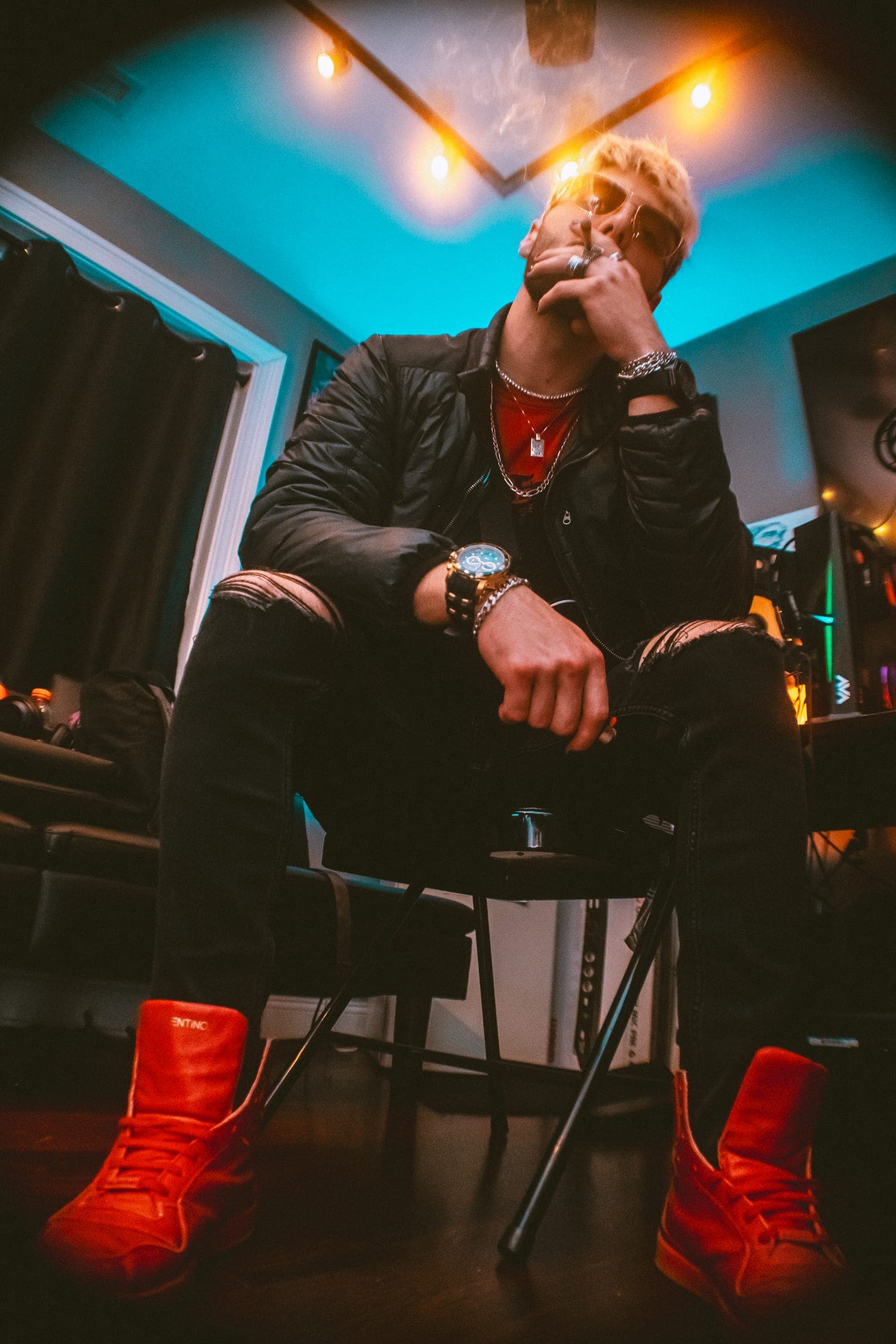 Artist seated in a studio wearing red sneakers