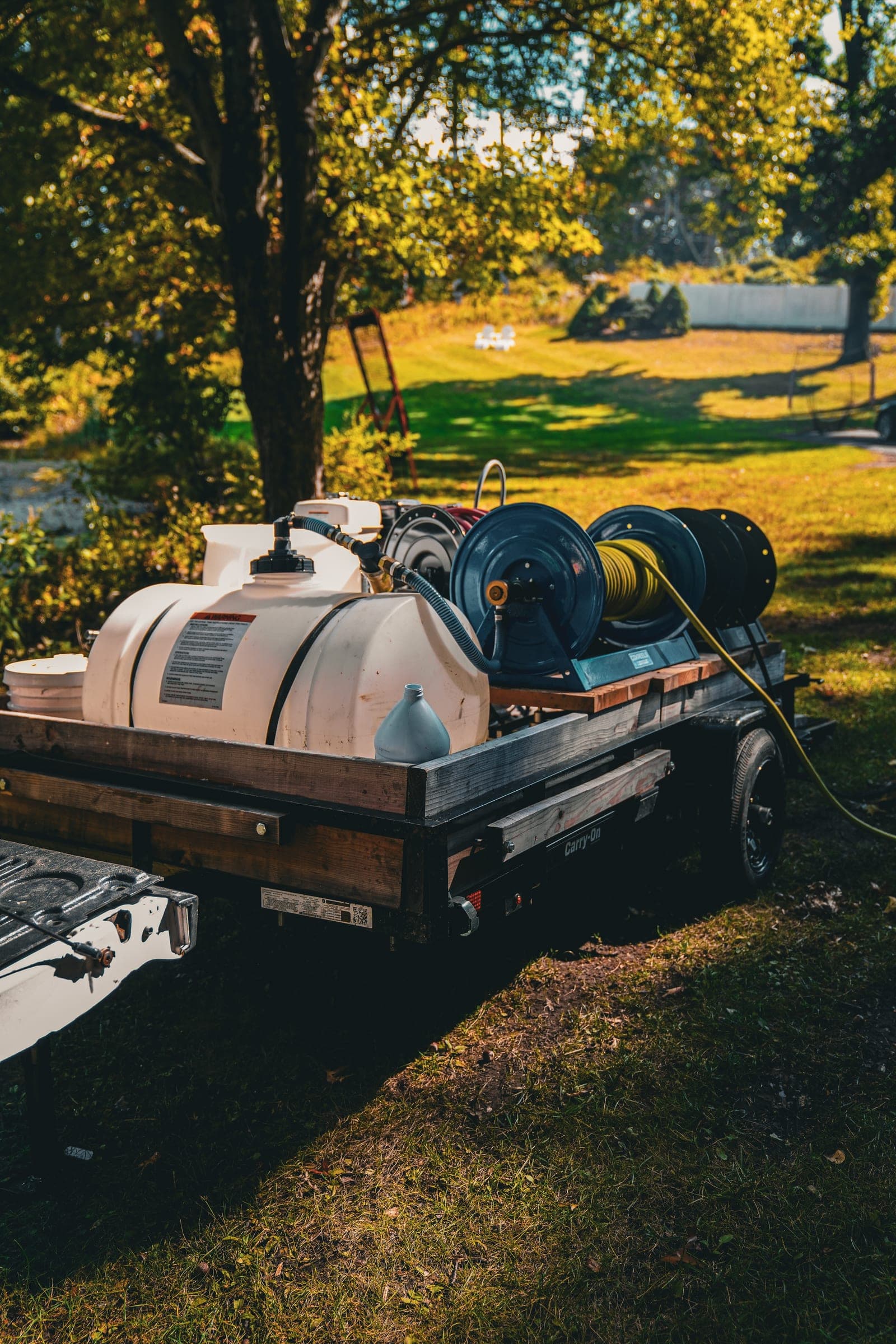 Pressure washing rig with hose reels on a trailer at golden hour