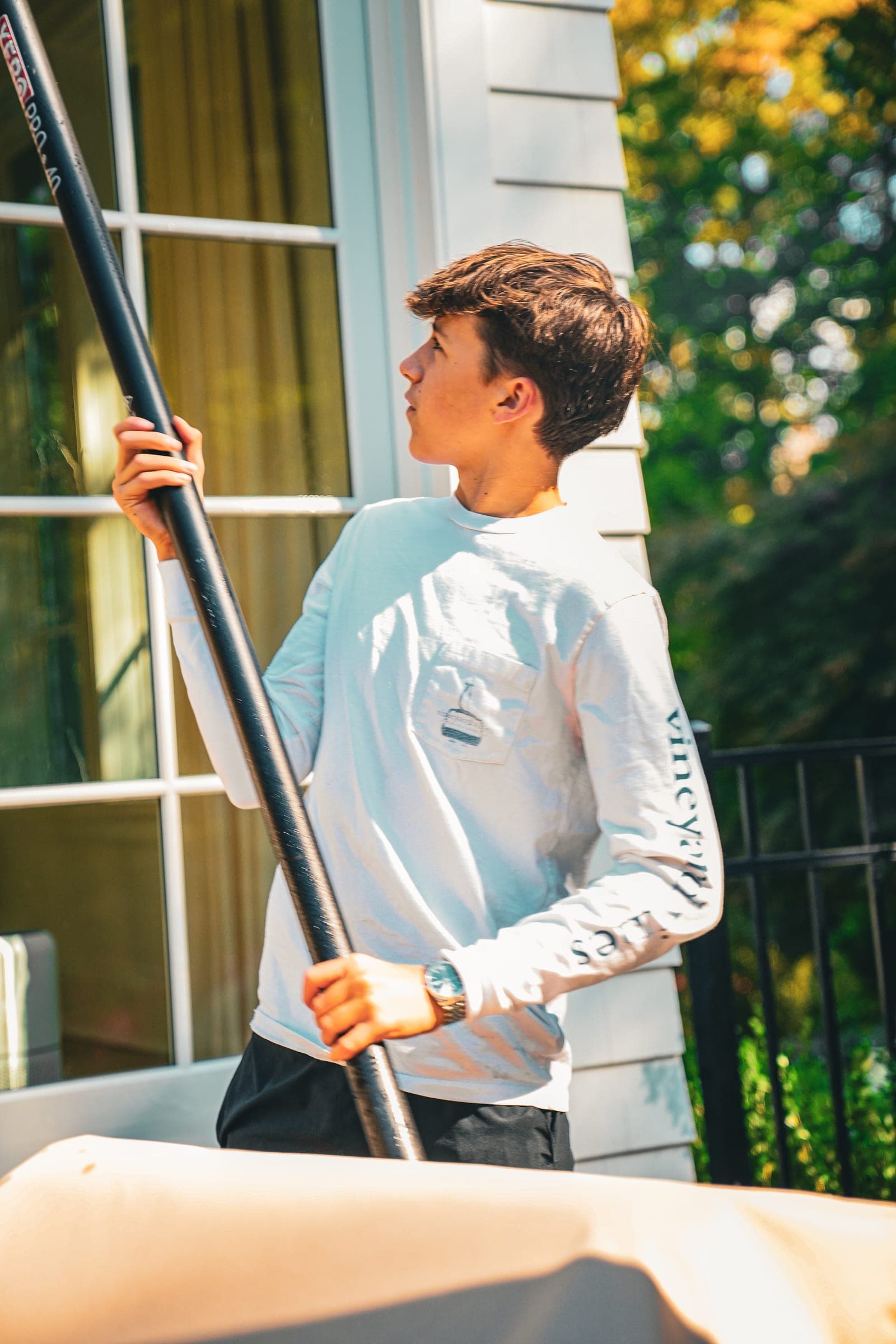 Cleaner looking up at the glass, pole in hand