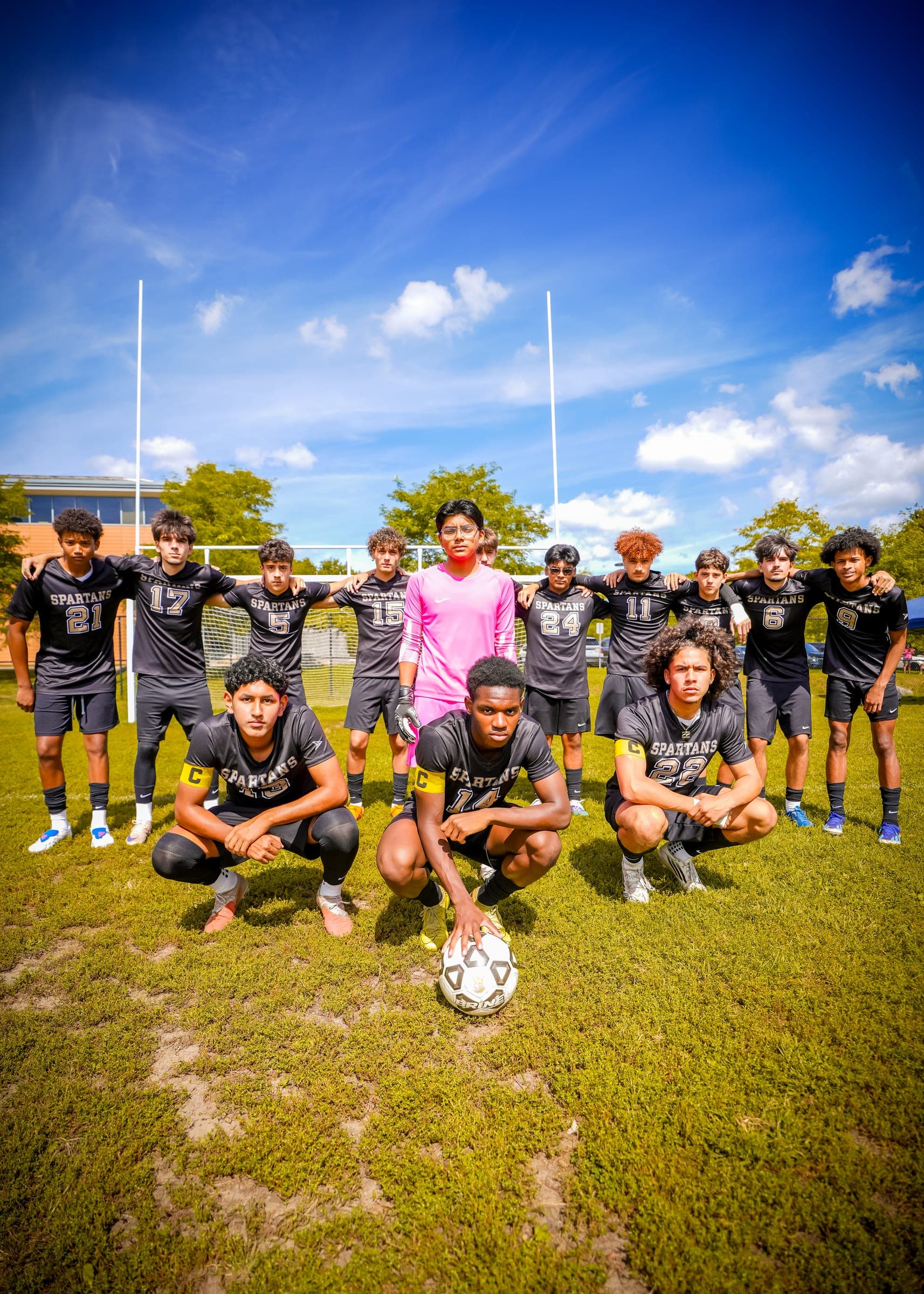 Soccer team posed on the field under a blue sky