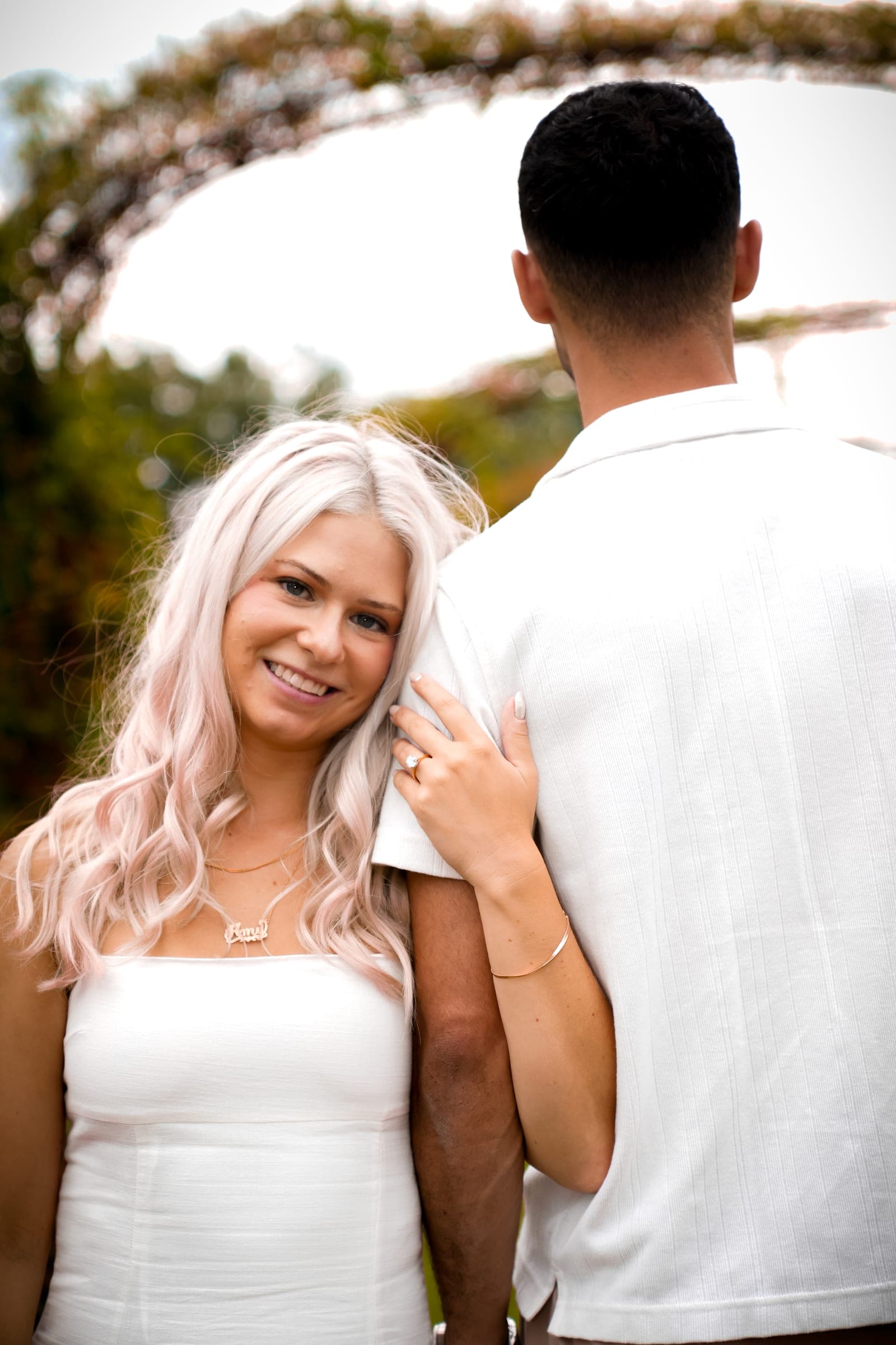 Bride-to-be smiling over her partner's shoulder